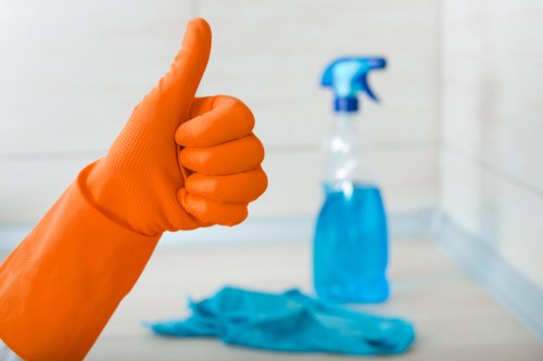 Professional cleaner sanitizing lift buttons in a shared property