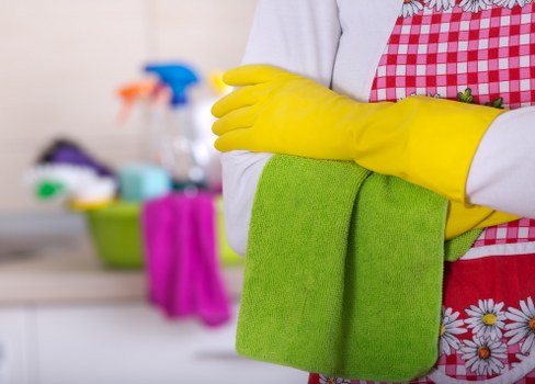 Professional cleaner disinfecting high-touch surfaces in a workplace